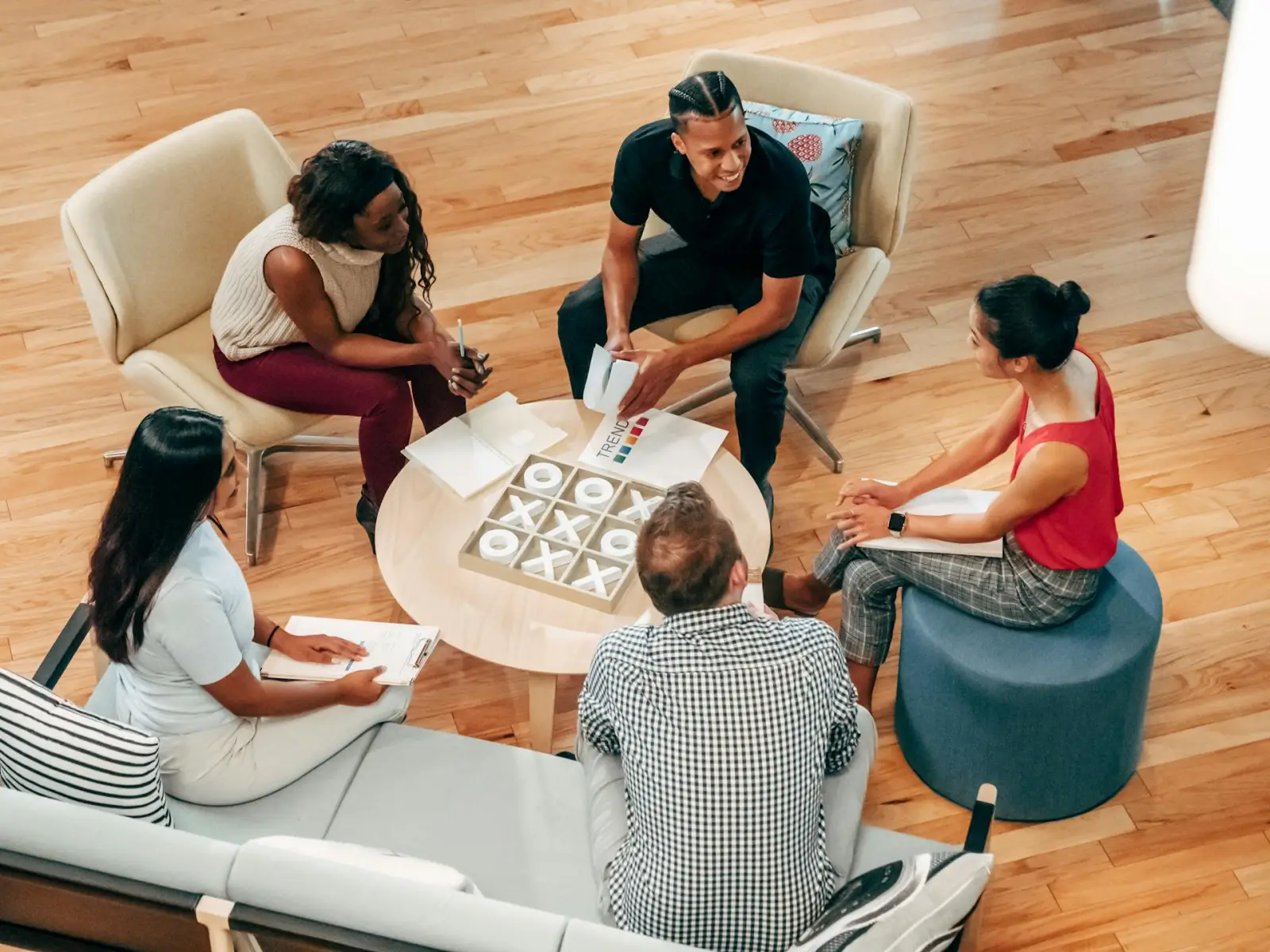 Diverse colleagues reviewing documents together around a coffee table in a sunlit office