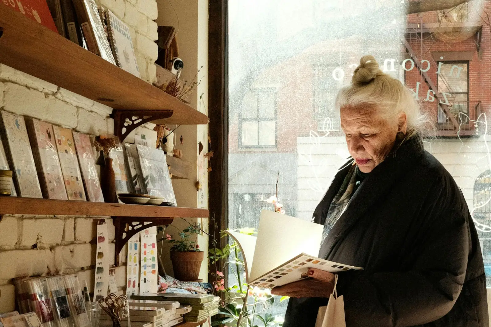 Older adult reviewing printed materials indoors with careful attention