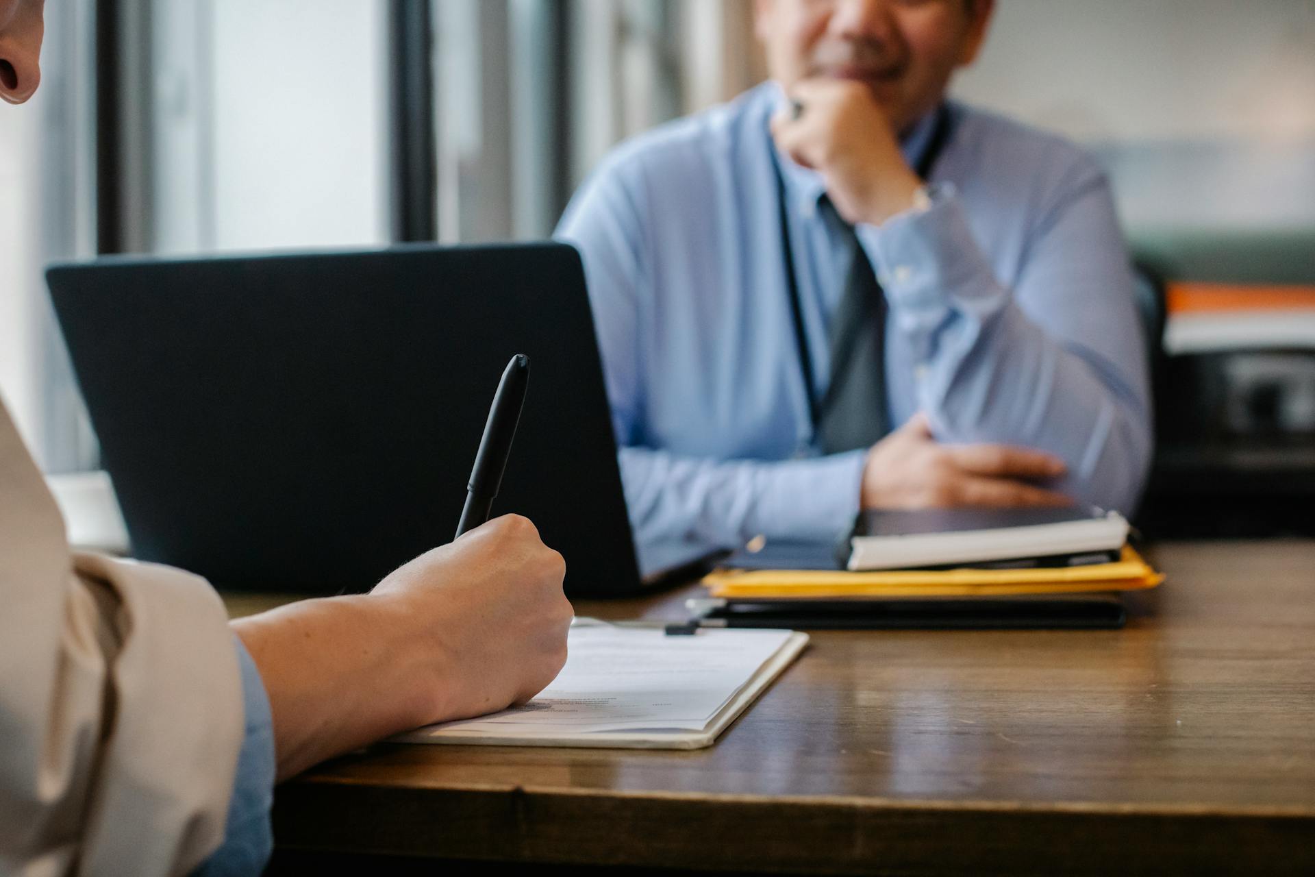 Attorney and client reviewing documents together across a desk in a bright modern office
